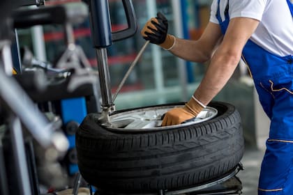 engineer balancing car wheel on balancer in workshop