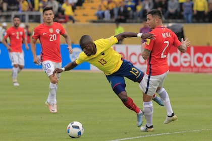 Enner Valencia lucha con el chileno Eugenio Mena, en el recordado partido jugado en el Atahualpa de Quito en 2016