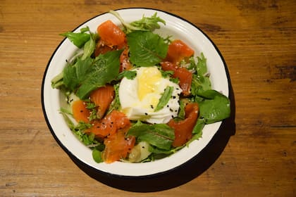 Ensalada de huevo poché, salmón ahumado y hojas frescas.