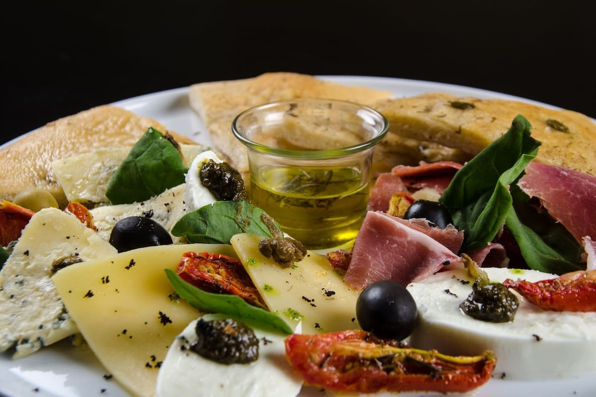 Ensalada de tomates, quesos, aceitunas y jamón con focaccia.