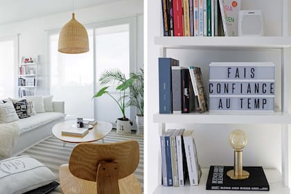 Entre los ventanales con cortinas roller, una biblioteca amurada laqueada en blanco con un cartel tipo marquesina con letras intercambiables y lámpara ‘Coco’ con base en tono oro mate (Lamps Crafts).