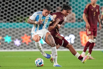 Enzo Fernández disputa la pelota con el venezolano Telasco Segovia; el argentino jugó 78 minutos del amistoso y terminó con una dolencia en la rodilla