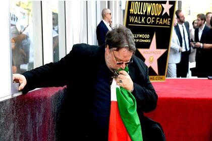 El cineasta mexicano besa la bandera de su país tras recibir el homenaje de la comunidad hollywoodense pocos días después del tiroteo en El Paso, Texas, que dejó 22 muertos