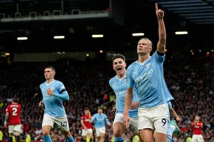 Erling Haaland, acompañado por Julián Álvarez y Phil Foden, celebra el primer gol de Manchester City ante el United, en el Old Trafford
