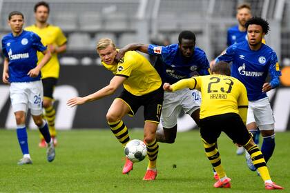 Erling Haaland de Dortmund, centro izquierda, pelea por el balón con Salif Sane de Schalke durante el partido de fútbol de la Bundesliga alemana entre el Borussia Dortmund y el Schalke 04 en Dortmund, Alemania, el sábado 16 de mayo de 2020.