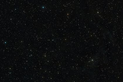 Esta imagen muestra el cielo que rodea a AT2019qiz, que es visible en el mismo centro de la imagen. Fue creada a partir de capturas del sondeo Digitized Sky Survey 2