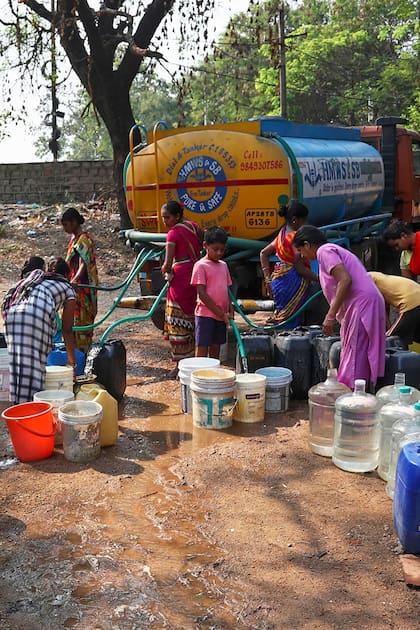 ESCASEZ: mujeres y niños se abastecen de agua potable de un camión cisterna en la zona de Hyderabad, India
