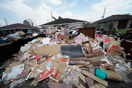 Escombros apilados en una acera luego que residentes despejaran sus casas inundadas tras el paso del huracán Ida en LaPlace, Luisiana, el martes 7 de septiembre de 2021. (AP Foto/Gerald Herbert)