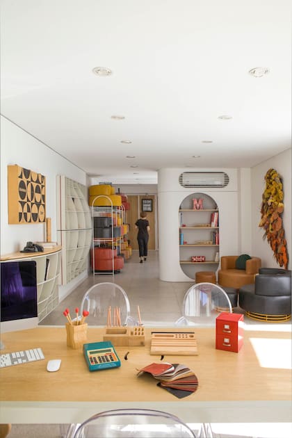 Escritorio (Irizar Kon) y sillas Ghost (Manifesto). Al fondo a la derecha, un panel móvil permite que este ambiente pueda ampliarse. Sobre el portón de madera, reloj Twemco, comercializado por el estudio.