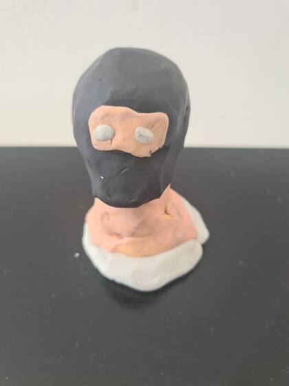 Escultura de plastilina de la imagen de un terrorista de Hamas encapuchado, realizada por un chico en el taller de Yael