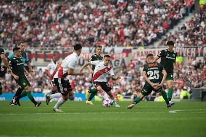 Esequiel Barco domina la pelota ante la mirada de varios futbolistas de Defensa y Justicia, previo a la suspensión