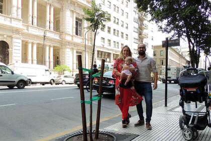 Esmeralda en los brazos de su mamá, Agustina Vlachovsky, y junto a su papá, Bruno Barrionuevo, sobre la avenida Callao donde está el árbol que apadrinará la familia