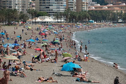 España empieza a recuperar la actividad turística, como en esta playa en Málaga