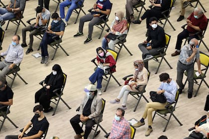 Esperas para la vacunación en Teherán (Photo by ATTA KENARE / AFP)