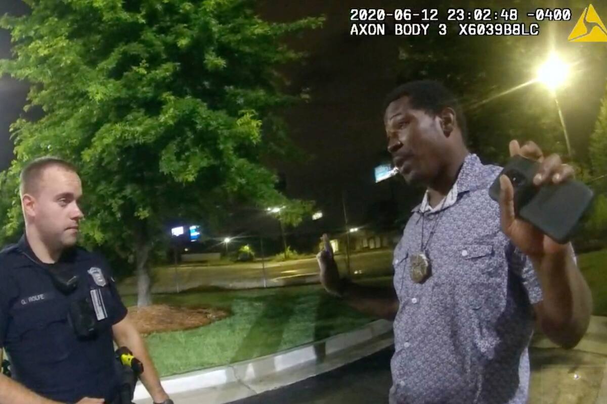 Esta captura de pantalla tomada del video de la cámara del cuerpo proporcionada por el Departamento de Policía de Atlanta muestra a Rayshard Brooks junto con el oficial Garrett Rolfe en el estacionamiento de un restaurante Wendys, el viernes 12 de junio de 2020 en Atlanta. Rolfe fue despedido luego