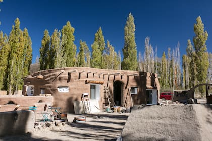 Está construyendo su nueva casa de forma redondeada en súper adobe. Tiene un cuarto a varios metros de profundidad que le valió el apodo de "el topo".