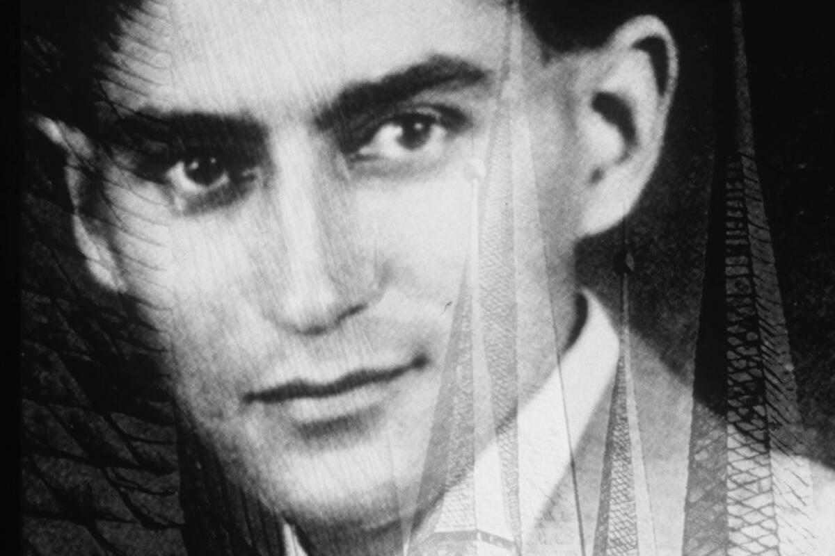 Esta es una foto de un montaje basado en una fotografía de 1917 de Franz Kafka, cuando tenía treinta y tres años, con una foto de los tejados de Praga.