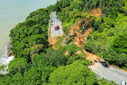 Esta foto difundida por la Defensa Civil de Ubatuba muestra la carretera SP-55 bloqueada por un deslizamiento de tierra en el municipio de Ubatuba, costa norte del estado de Sao Paulo, Brasil el 19 de febrero de 2023