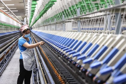 Esta foto tomada el 17 de abril de 2023 muestra a una empleada en una fábrica textil en Binzhou, en la provincia oriental china de Shandong.