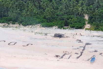 Esta fototomada el 2 de agosto de 2020 por la Fuerza de Defensa Australiana muestra las letras "SOS" en una playa en la isla Pikelot donde tres hombres fueron encontrados en buenas condiciones después de estar desaparecidos durante tres días