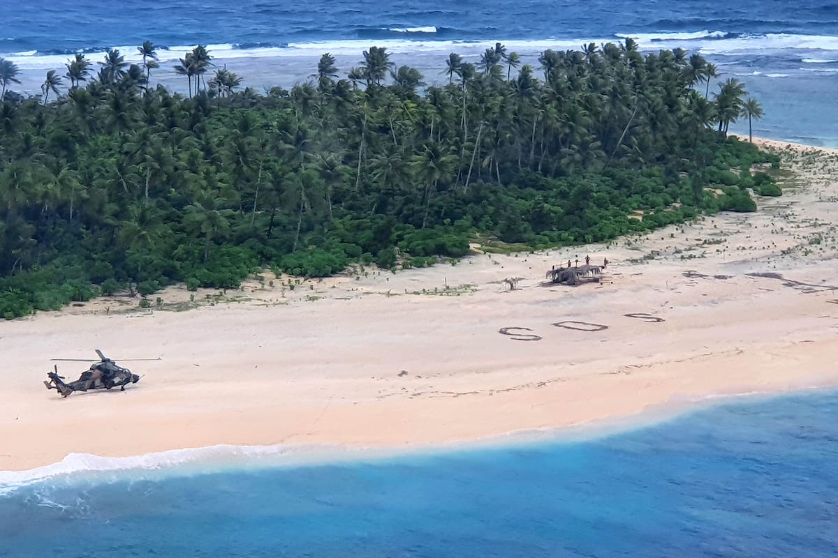 Esta foto tomada el 2 de agosto de 2020 por la Fuerza de Defensa Australiana muestra un helicóptero ARH Tiger del ejército australiano aterrizando cerca de las letras "SOS" en una playa en la isla Pikelot donde se encontraron a tres hombres en buenas condiciones después de estar perdidos p