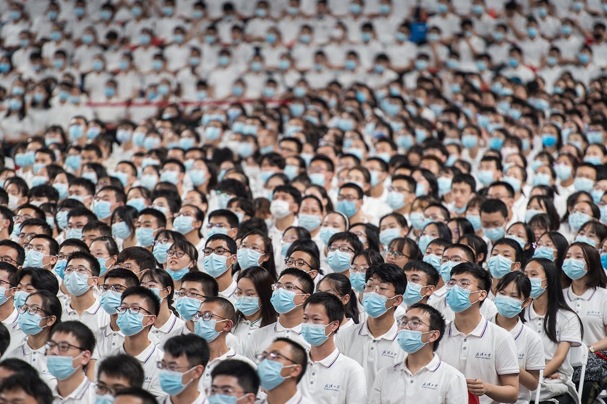 Esta foto tomada el 26 de septiembre de 2020 muestra a estudiantes de primer año con máscaras como medida preventiva contra el coronavirus durante una ceremonia de graduación en la Universidad de Wuhan