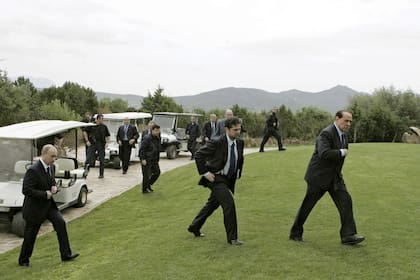 Esta fotografía de archivo tomada el 18 de abril de 2008 muestra al primer ministro italiano Silvio Berlusconi (derecha) y al presidente ruso Vladimir Putin (izq) caminando por el césped de Villa Certosa