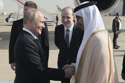 Esta fotografía distribuida por la agencia estatal rusa Sputnik muestra al presidente de Rusia, Vladimir Putin, estrechando la mano del ministro de Relaciones Exteriores de Emiratos Árabes Unidos, el jeque Abdullah Bin Zayed, a su llegada al aeropuerto de Abu Dhabi el 6 de diciembre de 2023.