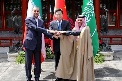 Esta fotografía facilitada por el Ministerio de Asuntos Exteriores iraní muestra al ministro de Asuntos Exteriores de Irán, Hossein Amir-Abdollahian, estrechando la mano del ministro de Asuntos Exteriores saudí, el príncipe Faisal bin Farhan, y del ministro de Asuntos Exteriores chino, Qin Gang, durante una reunión en Pekín el 6 de abril de 2023.