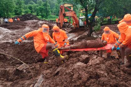 Esta fotografía proporcionada por la Fuerza Nacional de Respuesta a Desastres (NDRF) muestra a personal de emergencias recuperando el cuerpo de una víctima de un alud de tierra en Ratnagiri, en la región occidental india de Maharashtra, el domingo 25 de julio de 2021. Más de 100 personas murieron en el oeste de India debido a aludes e inundaciones provocados por el monzón. (Fuerza Nacional India de Respuesta a Desastres via AP)