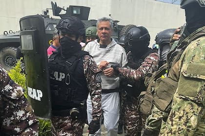 Esta fotografía proporcionada por la Policía Ecuatoriana muestra al exvicepresidente ecuatoriano Jorge Glas siendo escoltado por miembros del Grupo Especial de Acción Penitenciaria (GEAP) durante su llegada a la prisión de máxima seguridad La Roca en Guayaquil el 6 de abril de 2024.