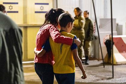 Esta fotografía publicada por las Fuerzas de Defensa de Israel (FDI) muestra al ex rehén israelí de 12 años Eitan Yahalomi (R) reunido con su madre luego de su liberación por parte de Hamas de la Franja de Gaza, en el punto de encuentro de Kerem Shalom a primera hora del 28 de noviembre, 2023.
