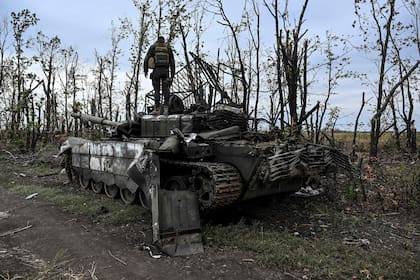 Esta fotografía, tomada el 11 de septiembre de 2022, muestra a un soldado ucraniano encima de un tanque ruso abandonado cerca de un pueblo en las afueras de Izyum, en la región de Kharkiv, en el este de Ucrania, en medio de la invasión rusa de Ucrania.