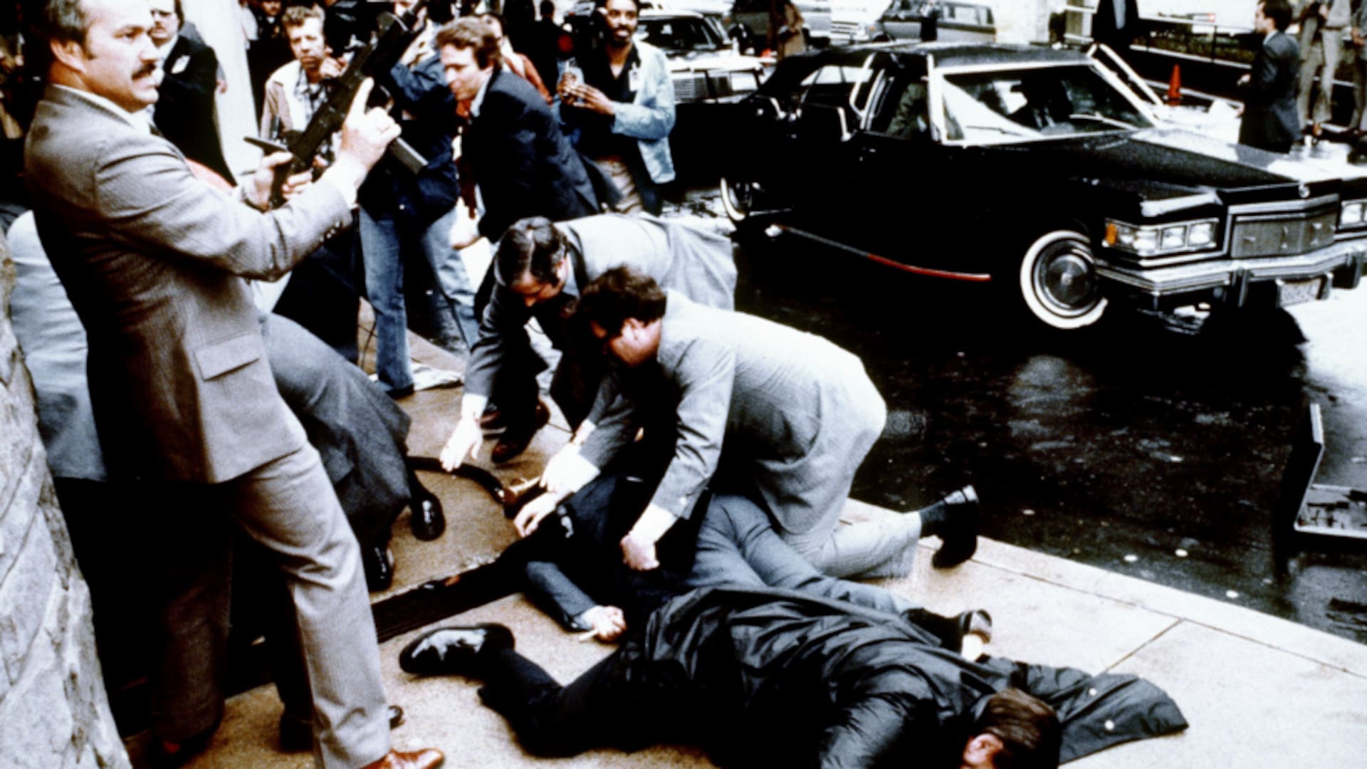 Esta fotografía, tomada por el fotógrafo presidencial Mike Evans el 30 de marzo de 1981, captura la reacción de la policía y los agentes del Servicio Secreto durante el intento de asesinato contra el entonces presidente de EE.UU., Ronald Reagan, tras una conferencia frente al Hotel Hilton en Washington, D.C..