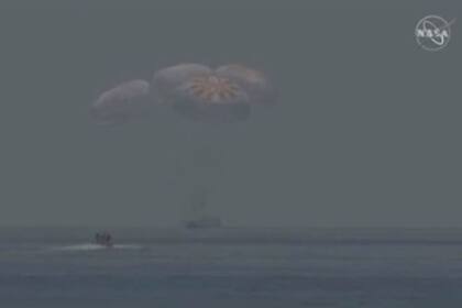 Esta imagen de captura de fotogramas de la NASA muestra lanchas que se mueven hacia la nave espacial SpaceX Crew Dragon después de su amerizaje frente a la costa de Pensacola, en Florida, el 2 de agosto de 2020