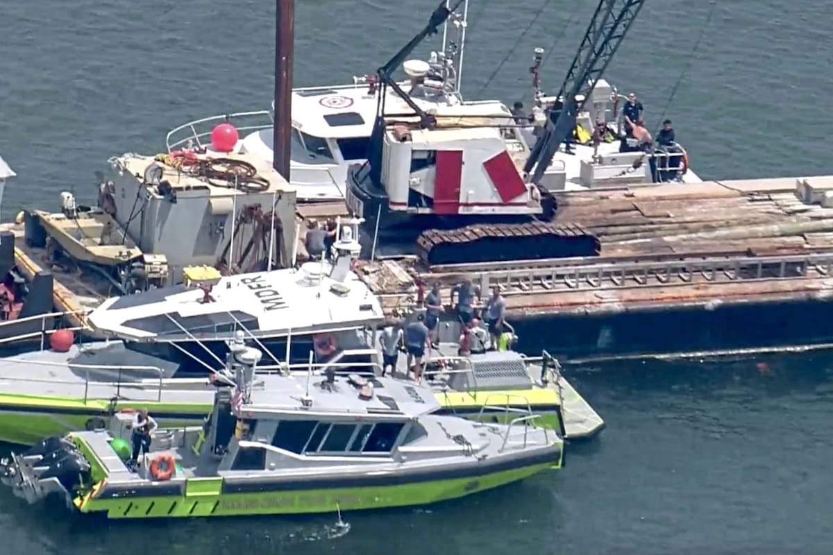 Esta imagen muestra al Cuerpo de Bomberos de Miami-Dade y a otros en botes alrededor de la barcaza que chocó contra el velero