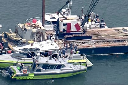 Esta imagen muestra al Cuerpo de Bomberos de Miami-Dade y a otros en botes alrededor de la barcaza que chocó contra el velero