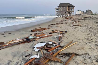 Esta imagen proporcionada por el Servicio de Parques Nacionales el viernes 16 de agosto de 2024, en Rodanthe, Carolina del Norte, a lo largo de la costa de la isla Hatteras, muestra escombros de una casa de playa desocupada que sufrió daños por los vientos y olas causadas por el huracán Ernesto. (Costa Nacional del Cabo Hatteras vía AP)