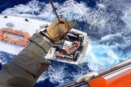 Esta imagen proporcionada por la Guardia Costera de EEUU se observa el rescate de un hombre mordido por un tiburón mientras pescaba a bordo de un barco cerca de Bahamas, el lunes 21 de febrero de 2022. (Guardia Costera de EEUU vía AP)