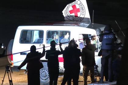 Esta imagen tomada de un vídeo de AFPTV del 25 de noviembre de 2023 muestra un vehículo de la Cruz Roja Internacional que supuestamente transporta rehenes liberados por Hamás conduciendo hacia el puesto fronterizo de Rafah con Egipto antes de su traslado a Israel.