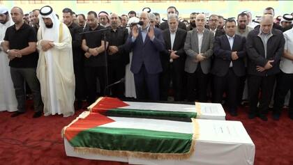 Esta imagen tomada de un video muestra a Khalil al-Hayya, alto funcionario de Hamas, orando frente a los ataúdes del líder asesinado de Hamas Ismail Haniyeh y de su guardaespaldas durante las oraciones fúnebres en Doha, Qatar, el 2 de agosto de 2024. (Qatar TV vía AP)