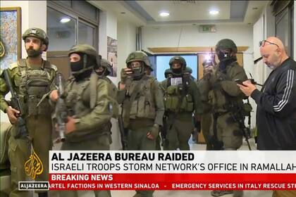 Esta imagen tomada de un video y proporcionada por Al Jazeera English muestra tropas israelíes allanando su oficina en Ramala, Cisjordania, el domingo 22 de septiembre de 2024. (Al Jazeera via AP)