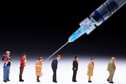 Esta imagen tomada en París muestra figurillas y una jeringa para ilustrar a las personas que reciben la vacuna contra el coronavirus