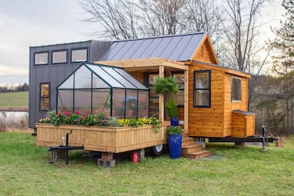 Esta pequeña casa combina madera, chapa y tiene un invernadero