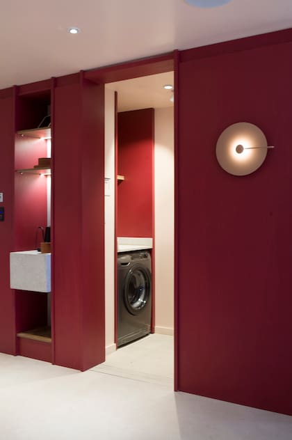 Esta propuesta del estudio Marini en Experiencia Living Bliss, nos muestra un lavadero con identidad resaltando el tono bordó para que se integre a la cocina. Más allá de su absoluta necesidad, la iluminación invita a mirarlo e integrarlo tanto a la zona de servicio como al espacio social.