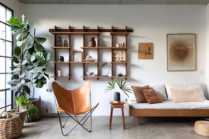 Estantería (La Base). Adornos y florero de cerámica (Philippa Deco Boutique). Canasto de fibras naturales con planta (Claudia Adorno).