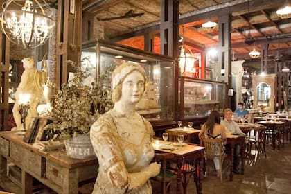 Estatuas y arañas antiguas se mezclan entre las mesas del restaurante Nápoles