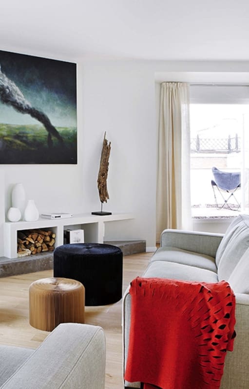 Este es un departamento lleno de detalles, como la manta calada (Nanimarquina) puesta en uno de los sillones o la escultura de madera originaria de Asia que descansa junto a la obra pictórica central del ambiente