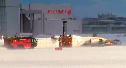 Este fotograma de un video de CTV muestra a socorristas junto a un avión volcado en el Aeropuerto Pearson de Toronto el lunes 17 de febrero de 2025