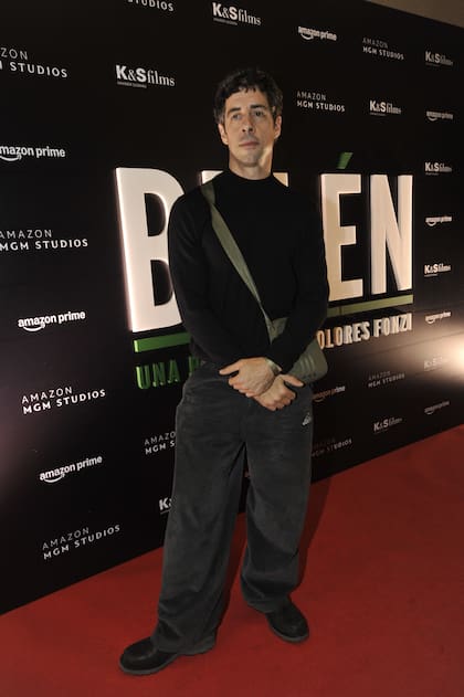 Esteban Lamothe, muy canchero con pantalón oversize gris, polera negra y morral cruzado